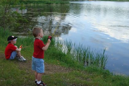 Boys sitting on shore fishing