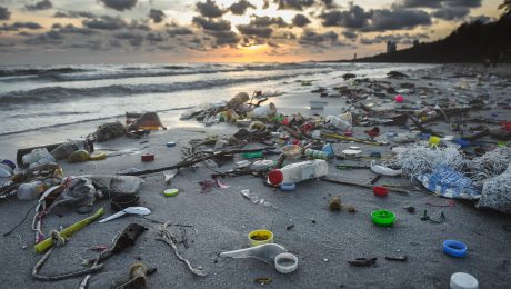 Dirty beach environment from plastic garbage. Trash scattered across the beach.